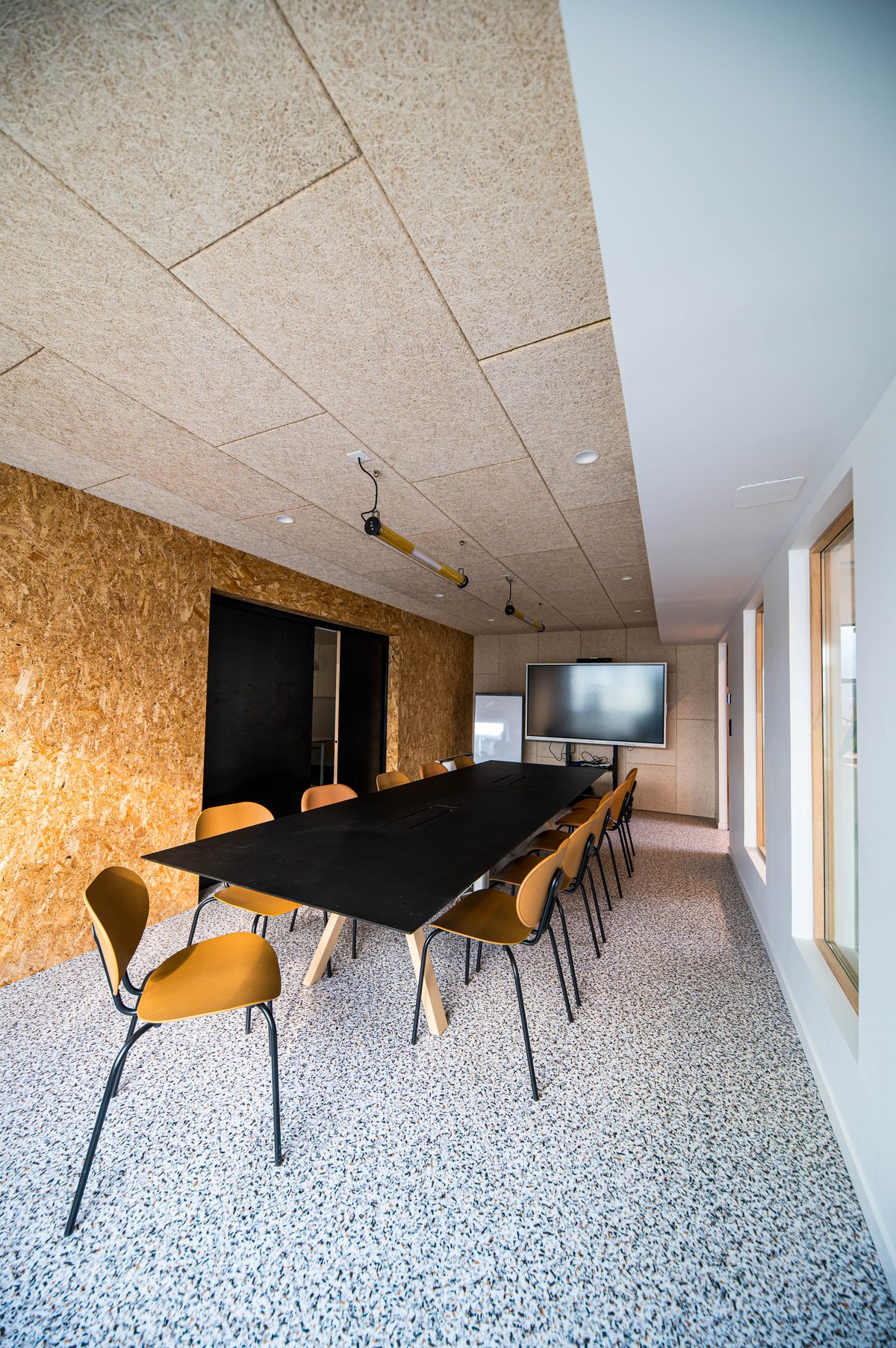 Salle de réunion du campus, aménagée en matériaux biosourcés, avec écran interactif